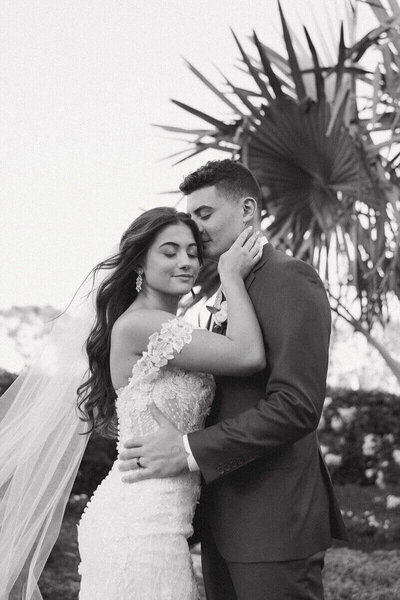 groom kissing bride on temple by wedding photographer in south florida