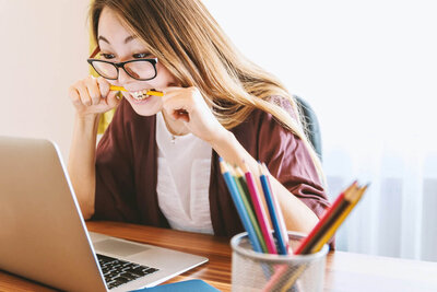 Entrepreneur woman with glasses looking at her computer, trying to do admin work