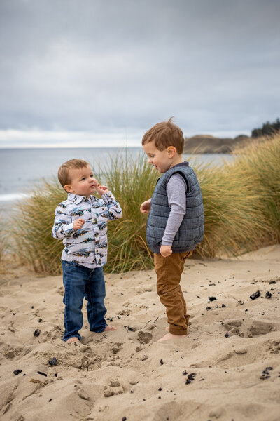 Portland family photography captures sibling boys playing on the Oregon Coast beach.
