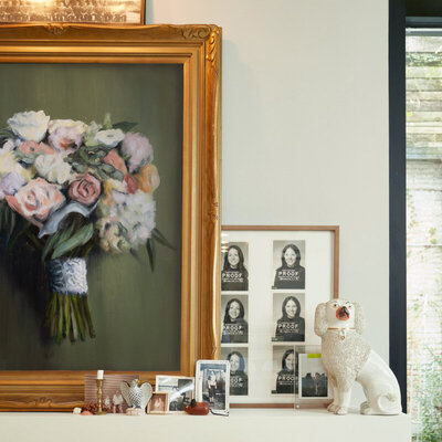 Alyssa's bright floral wedding bouquet artwork, framed in gold in a modern interior home.