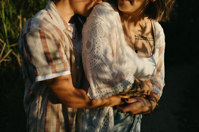 Two people embracing outdoors, wearing casual clothing. One has a lace shawl, and the other sports a striped shirt. Captured by a Toronto family photographer, this moment beautifully reflects connection and warmth in everyday life.
