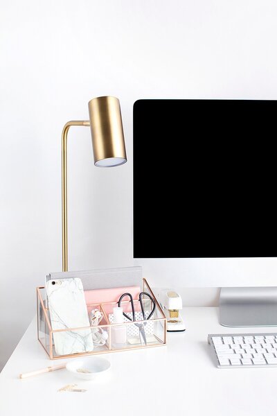 Gold dekstop lamp next to an apple computer on a white gloss finish desk