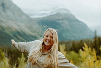 woman smiling in front of mountainscape
