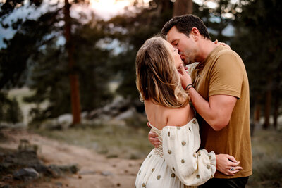 A husband and wife sharing a kiss at sunset in rocky mountain national park.
