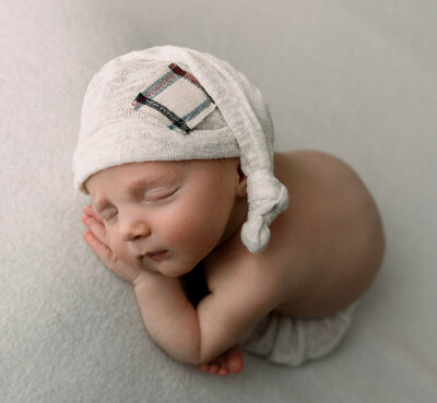Newborn baby boy with a sleepy cap on