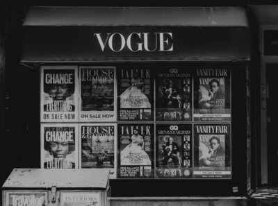 Black and white photo of a Vogue awning with magazine covers underneath