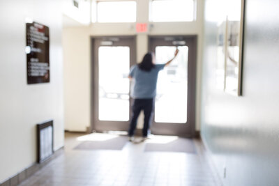 Professional cleaner washing windows in the entrance way