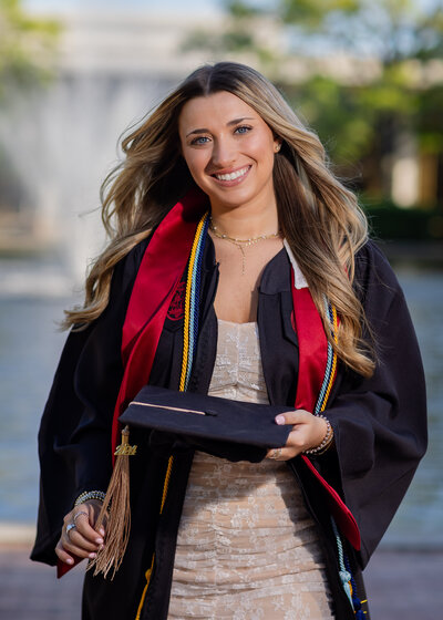 A University of South Carolina student taking her senior portraits on campus in front of the Thomas Cooper Library fountain