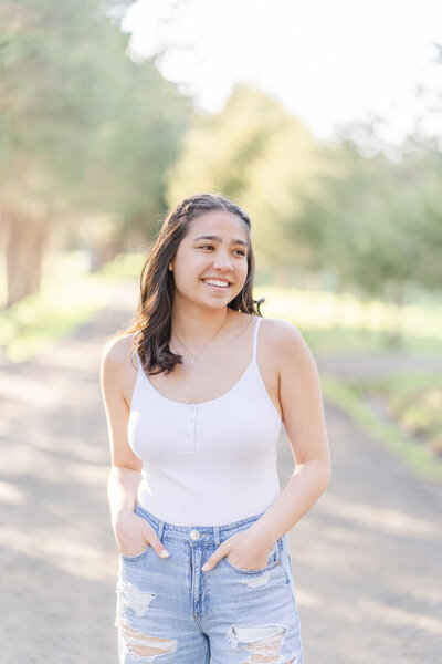 girl smiling with hands in her pocket during Gainesville, Virginia senior pictures