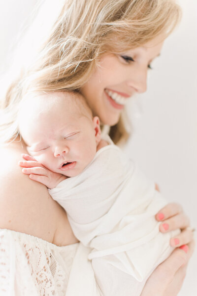 newborn photo session with mom in off the shoulder dress.
