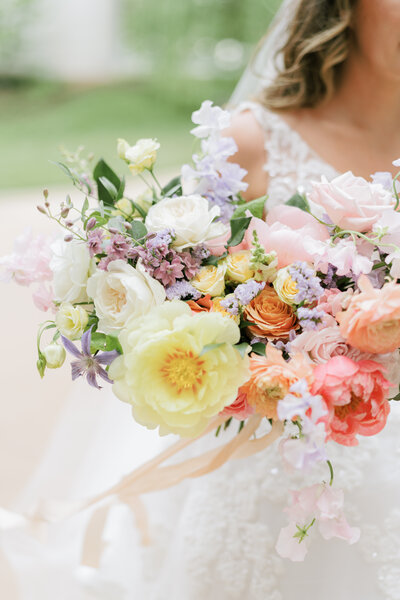 bride outdoors holding wedding bouquet