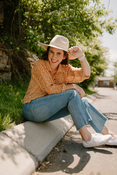 woman smiling while wearing hat