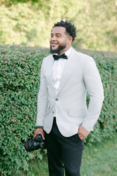 Larry smiling while holding a camera