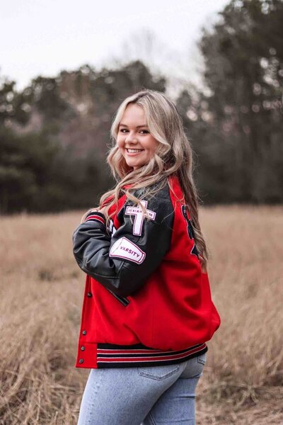 Karlee poses in senior jacket for graduation photos in Houston