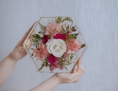 hands holding up a preserved wedding bouquet hexagon 