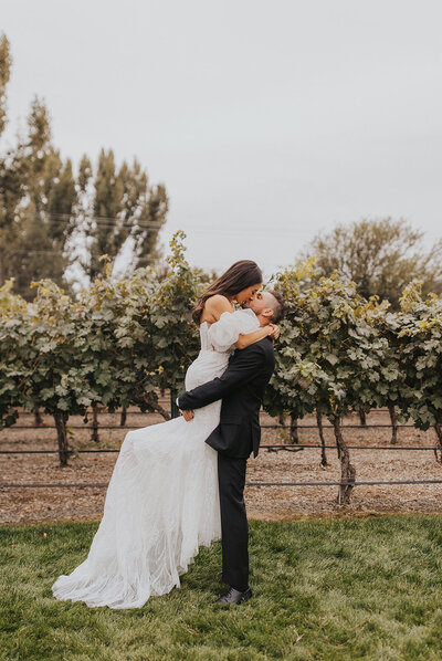 Bride and groom kissing in the vineyards