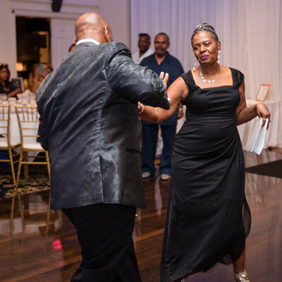 Photo of married couple dance with guests cheering, captured by Sugar Grove  wedding and event photographer Kesha Wright