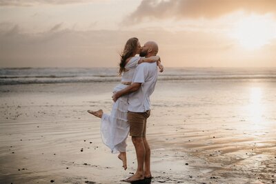 A couple kissing and holding one another during their engagement photoshoot