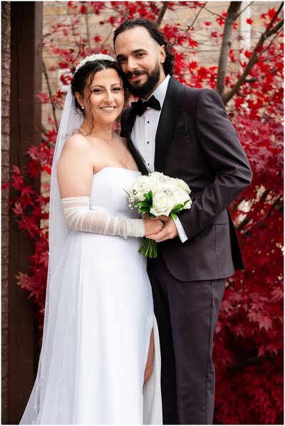 Couple walking towards The arlington Estate main building, just married and heading towards their reception. The brideis looking back and smiling while the groom keeps looking away holding her hand and giving his back to the camera