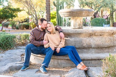 Couple cuddling in front of fountain at Rancho Manana golf course in Cave Creek, Arizona
