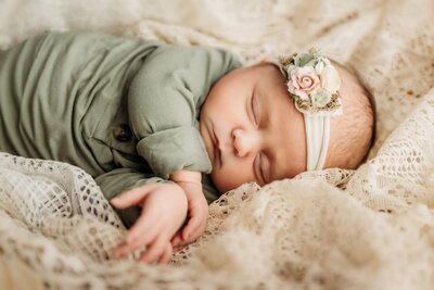 newborn baby sleeping on vintage lace