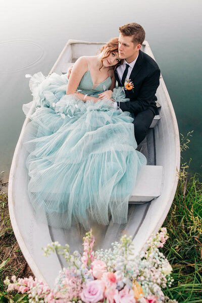Couple dressed up in a row boat on the water