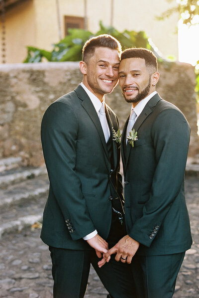 Romantic portrait of two grooms standing together at sunset during their destination wedding — captured with warmth and authenticity by Asia Pimentel Photography