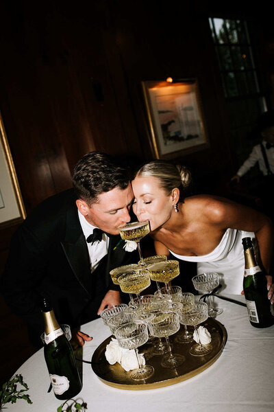 Bride and groom drinking from champagne tower