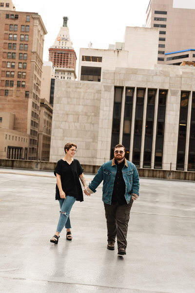Couple captured in a romantic moment in a downtown setting, surrounded by city streets.