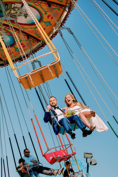 Newlyweds riding a swing ride together 