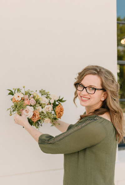 Kendra Moran, floral designer, skillfully arranging a bouquet in her studio.