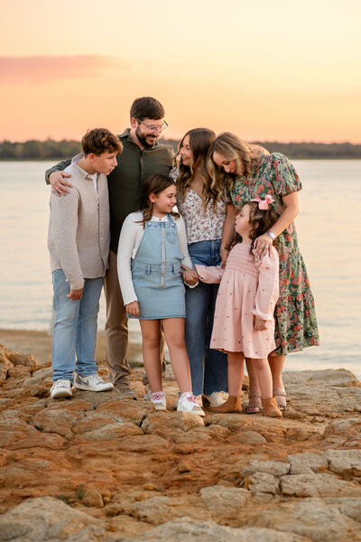 a family of five is photographed by the lake