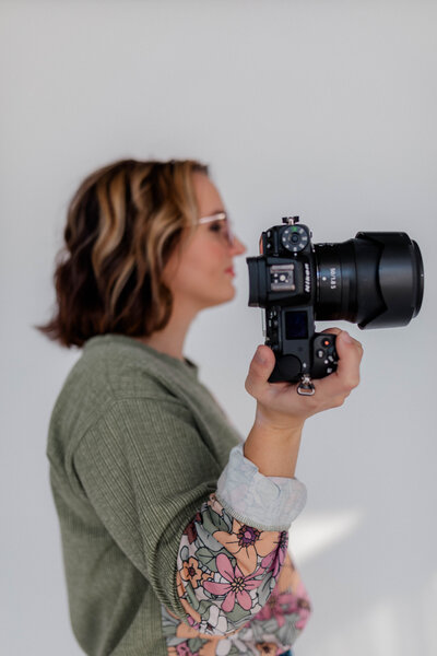 Woman poses for the camera with Nikon Z6II Camera in hand.