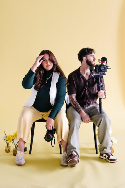 A person sitting on a chair as their partner leans on their back