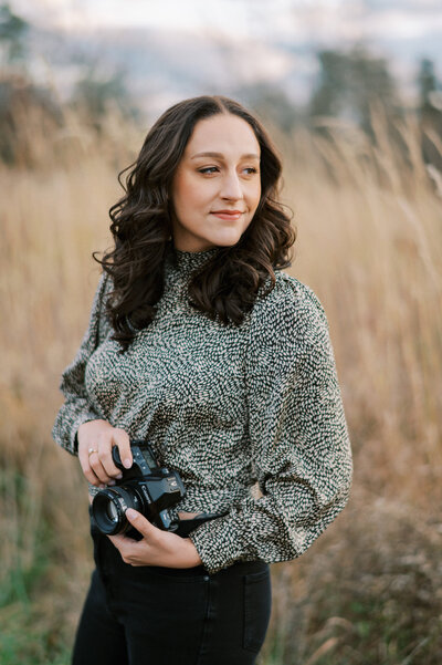 A portrait of the photographer Melissa Palka holding a camera at Manassas Battlefield Park in Virginia