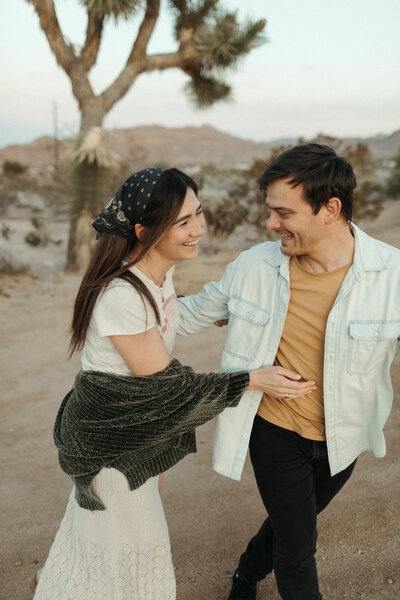 A couple enjoying a photoshoot together in Joshua Tree, CA desert landscape.