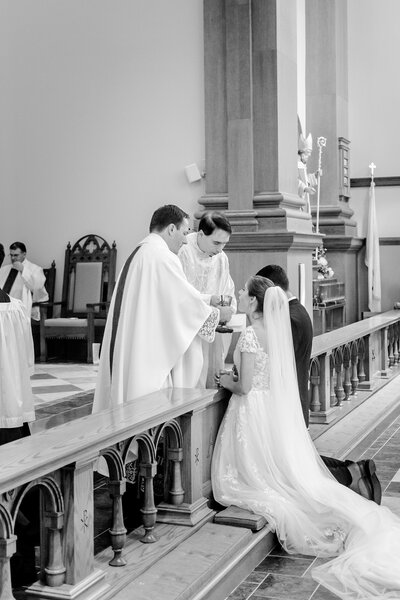 A bride receiving communion during her Catholic wedding in Northern Virginia