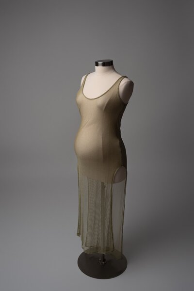 Sleek gold slip dress with subtle sheen, displayed in Austin maternity wardrobe