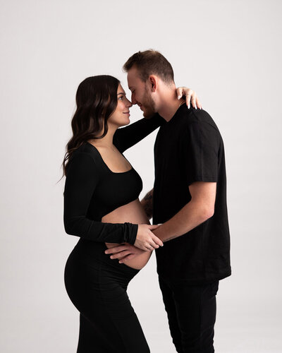 Couple embraces for their belly maternity portraits in Greensburg  photography stuido.