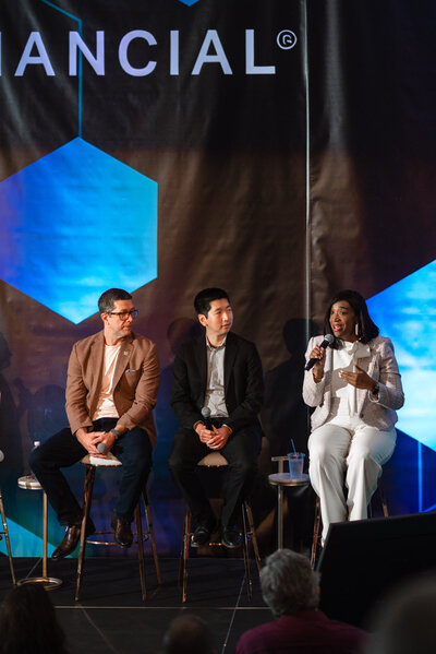 Panel of business professionals speaking on stage during a corporate conference at the Dubois Center in Charlotte, NC, photographed by DeLong Photography, a Charlotte event photographer.