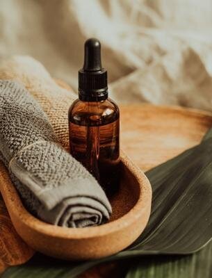 Aromatherapy oil bottle on a wooden bowl with spa towel