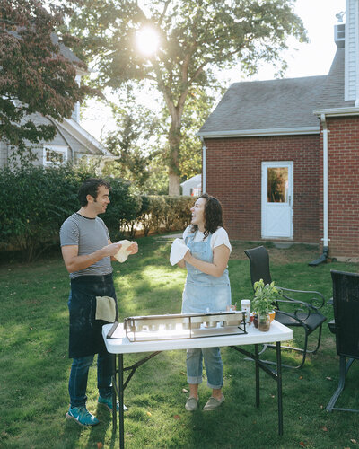couple making pizza during at home engagement photos, captured by Elsie Goodman, an NYC engagement and couples photographer