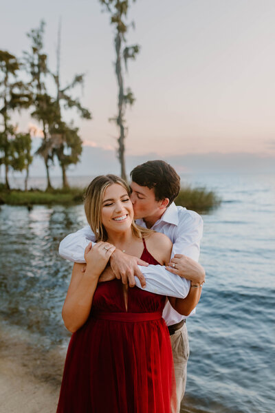 Engaged couple snuggling close during their photoshoot in Mandeville, LA