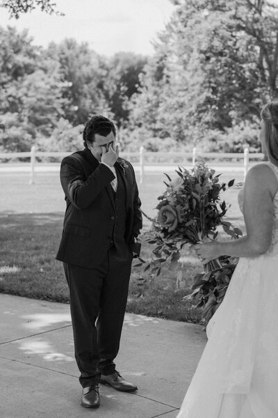 A person wiping tears from their eyes during their first look 