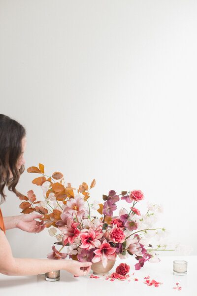 Pink floral arrangement in front of a white wall
