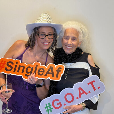 Two women with funny signs at photo booth