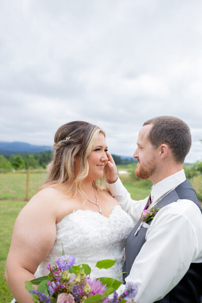 Seattle Wedding Photographer Investment Packages with couple first look and groom brushing hair out of brides face