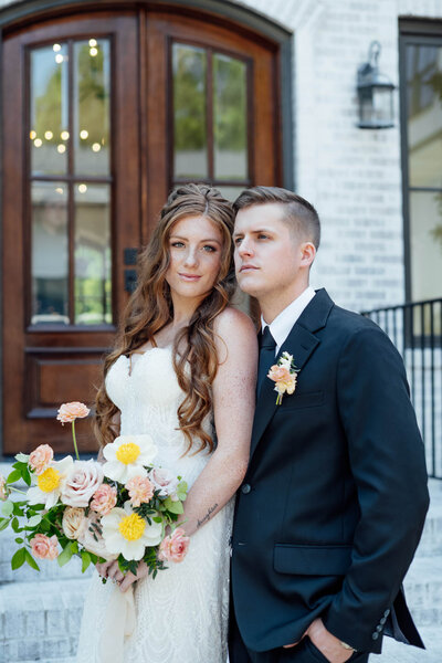 Bride and groom posing with bouquet