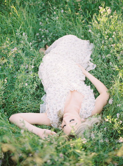 Expectant mother laying in the grass in beautiful gown, captured by Edmonton maternity photographer, Kahla Kristen