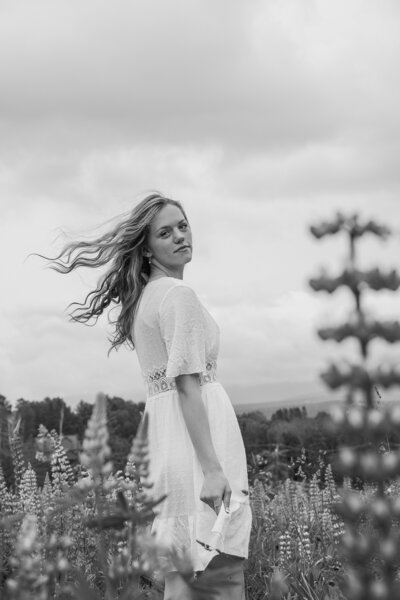 Black & White photo with girl wearing dress with hair blowing in the wind